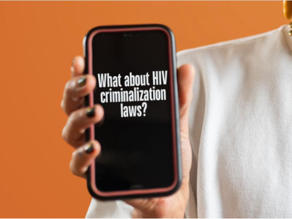 Orange pbackground pic on man holding cell phone that reads "What about HIV criminalization laws?"